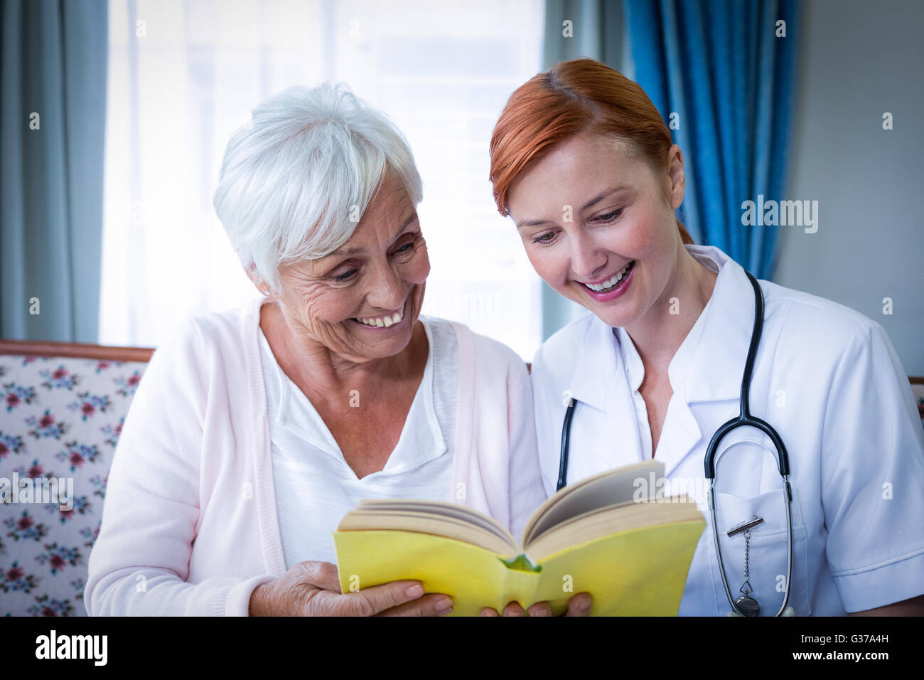 Felice il paziente e il medico la lettura di un libro Foto Stock