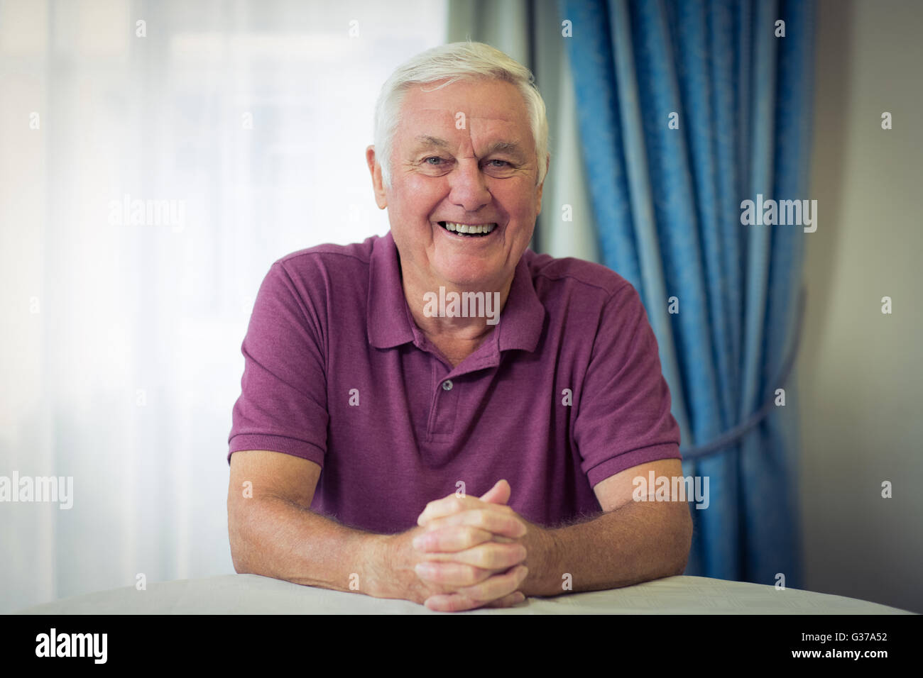 Ritratto di senior uomo seduto in clinica medica Foto Stock