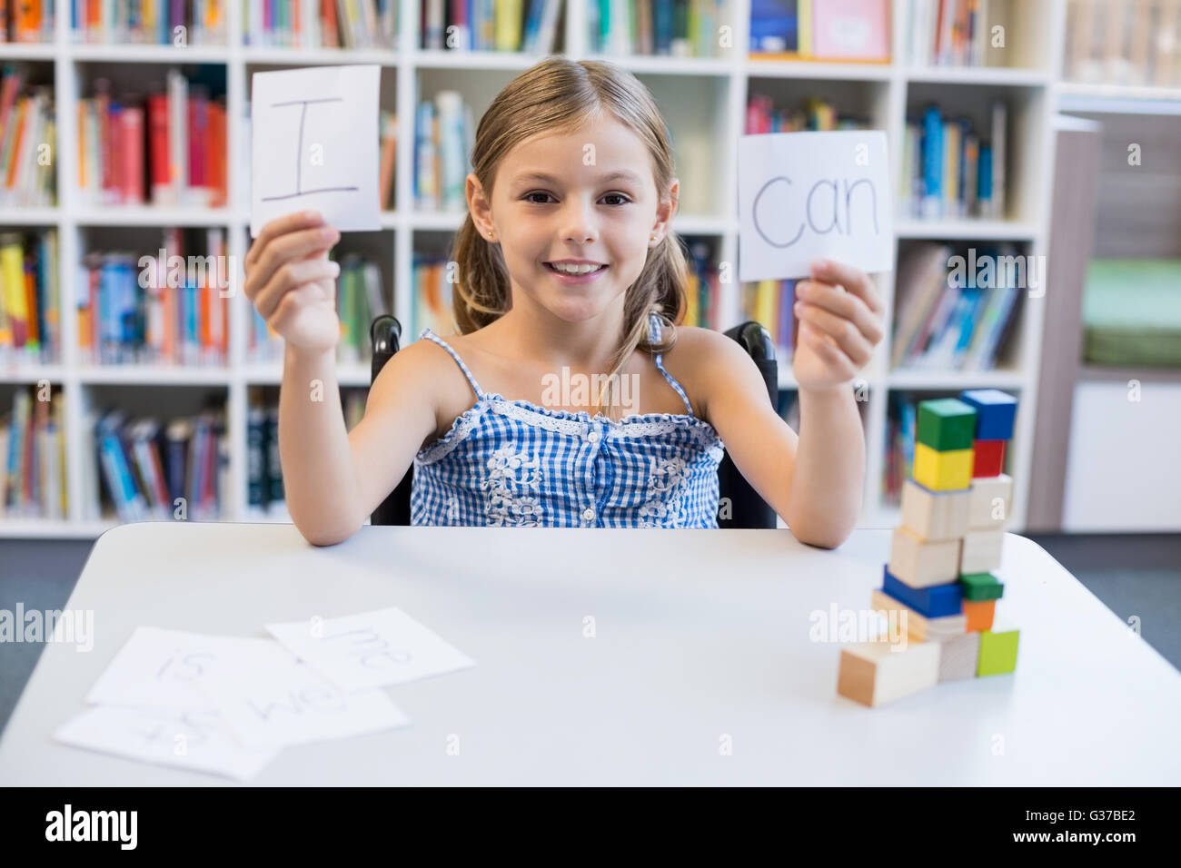 Disabilitato ragazza con cartello che dice che posso in libreria Foto Stock