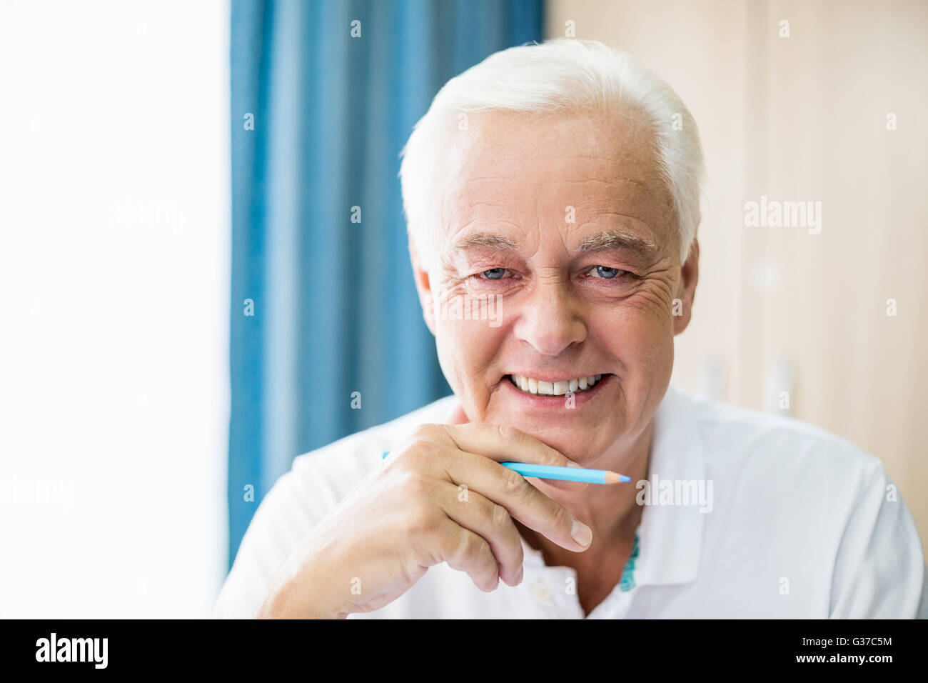 Sorridente senior tenendo la matita colorata Foto Stock