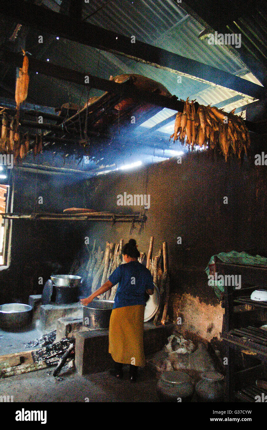 Il riscaldamento delle donne dal focolare nelle zone rurali del Myanmar Birmania, Kengtung, Kyaingtong Foto Stock