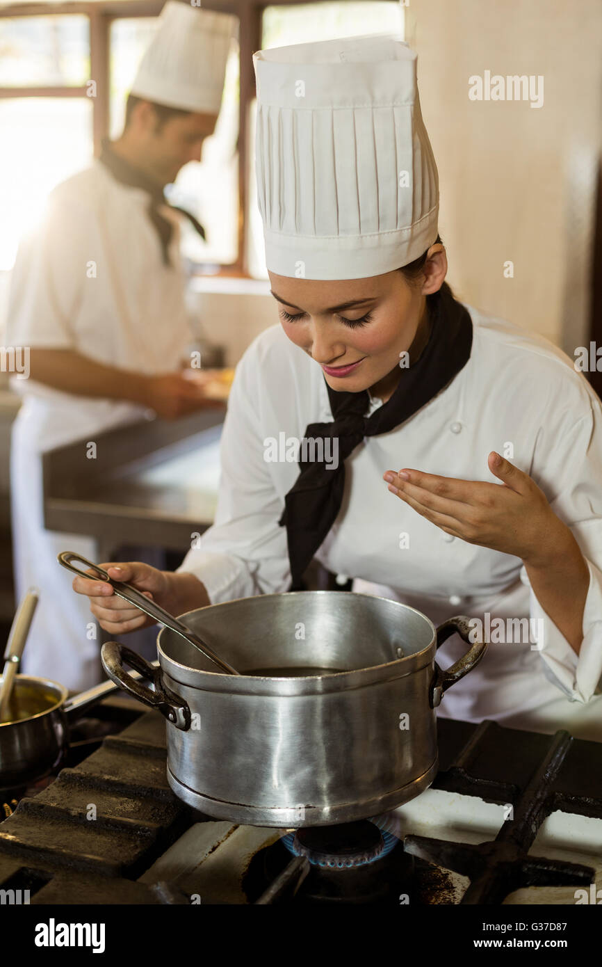 Sorridente capo chef agitazione nel recipiente di cottura Foto Stock