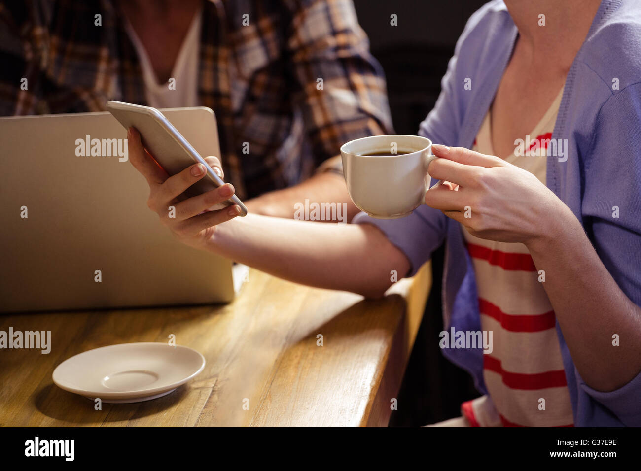 Focus su una tazza di caffè e telefono Foto Stock