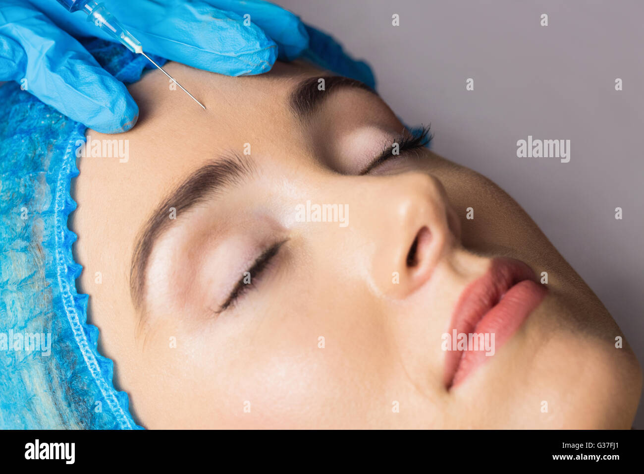La donna la ricezione di botox iniezione sulla sua fronte Foto Stock