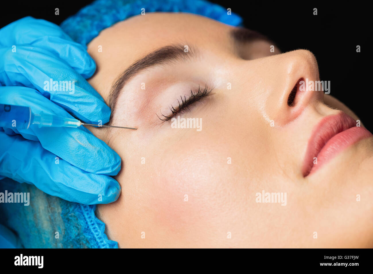 La donna la ricezione di botox iniezione sulla sua fronte Foto Stock