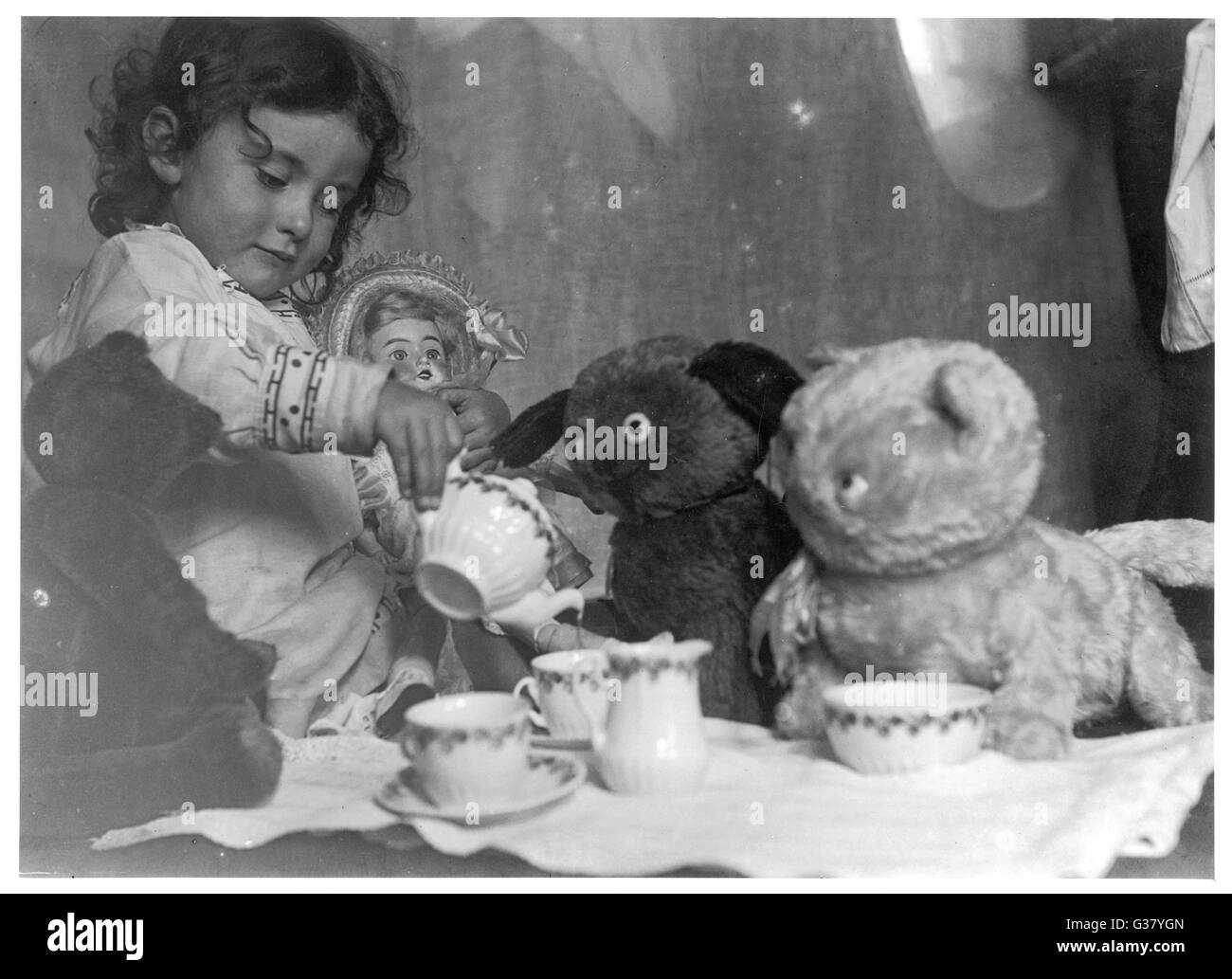 Una bambina ospita un tea party - tre orsi e una bambola di partecipare. Data: settembre 1915 Foto Stock