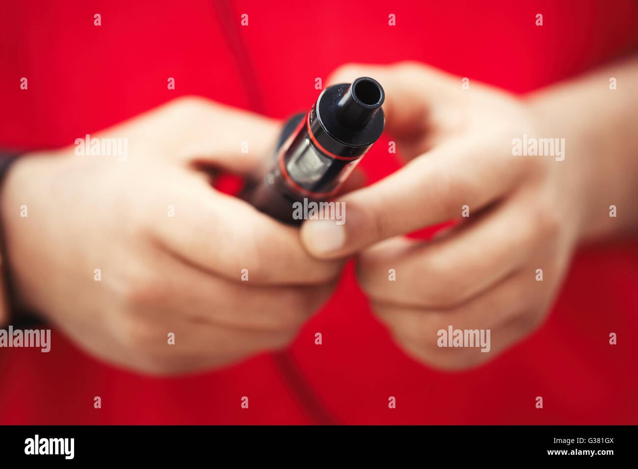 Mani di African maschio modello utilizzando i moderni e-cig dispositivo vaporizzatore per il fumo liquido di glicerina tabacco con gusto. Gadget popolare tra i giovani e che desiderano migliorare la salute e a smettere di fumare Foto Stock