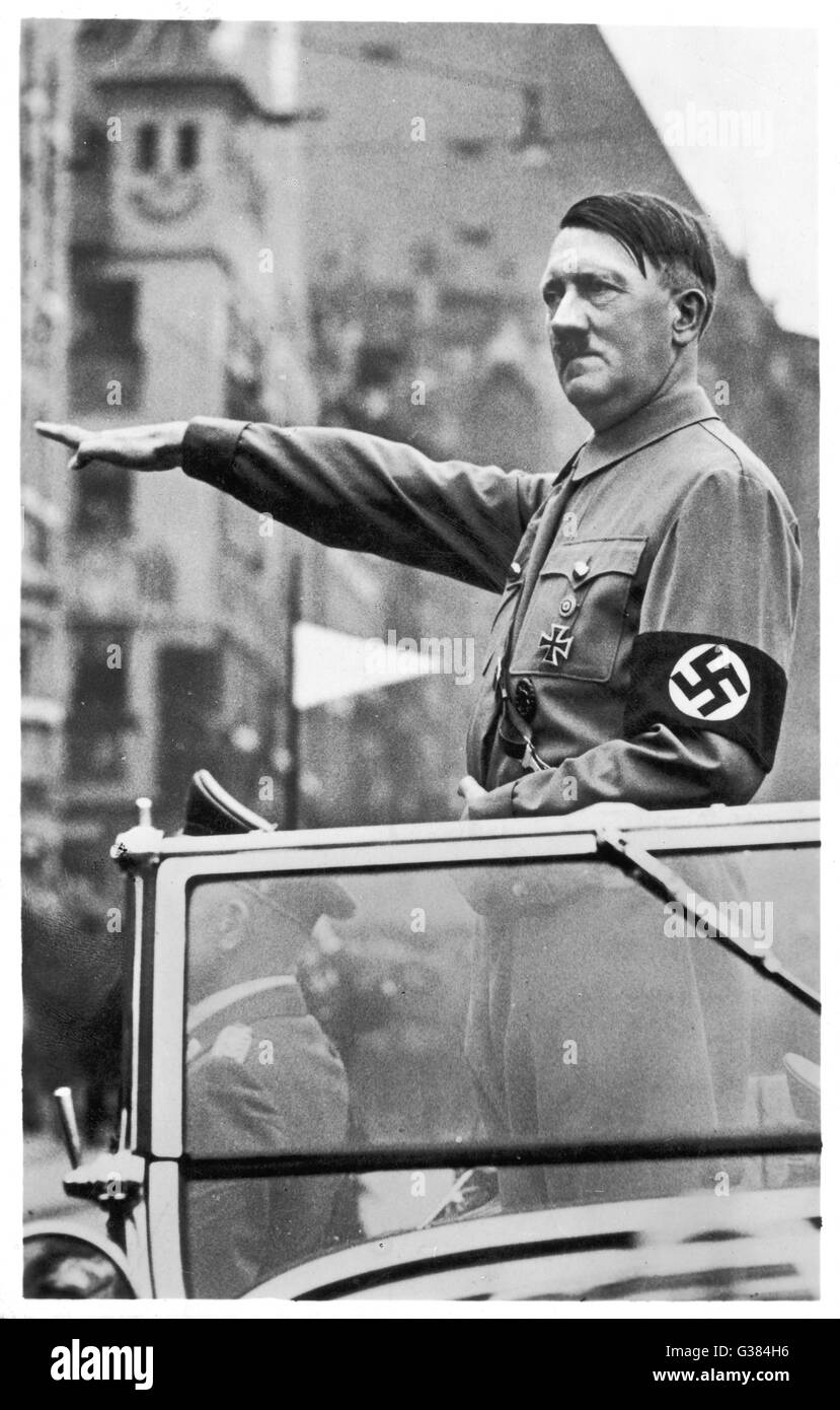 Uomo politico tedesco e leader, ADOLF HITLER, gesticulates dalla sua auto in un rally di Norimberga. Data: 1938 Foto Stock