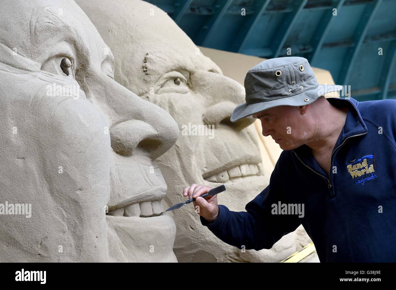 Scultore di sabbia 'Marca Anderson' mette i tocchi di rifinitura per la scultura della Regina Elisabetta e il Principe Filippo, Dorset, Regno Unito Foto Stock