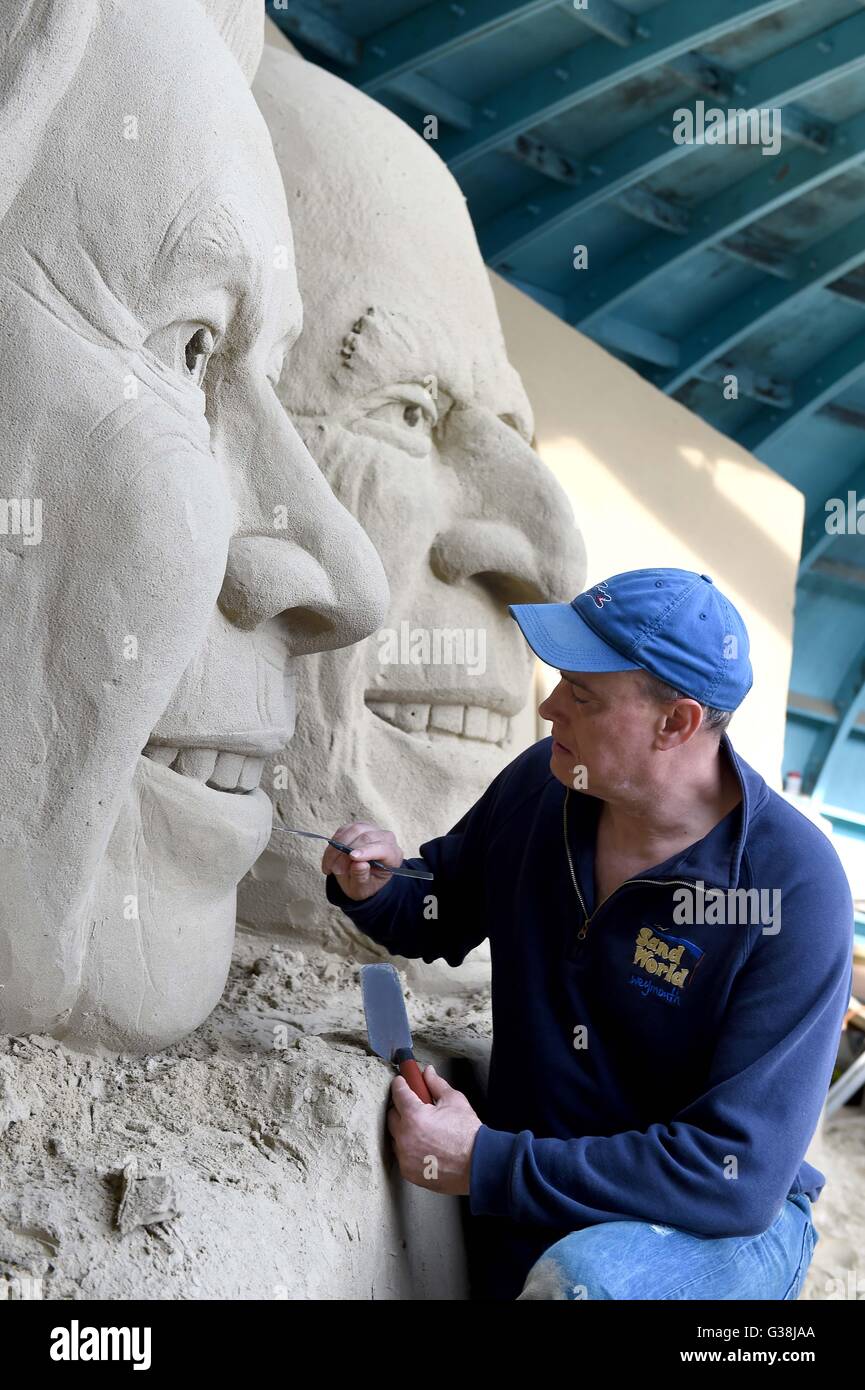 Scultore di sabbia 'Marca Anderson' mette i tocchi di rifinitura per la scultura della Regina Elisabetta e il Principe Filippo, Dorset, Regno Unito Foto Stock