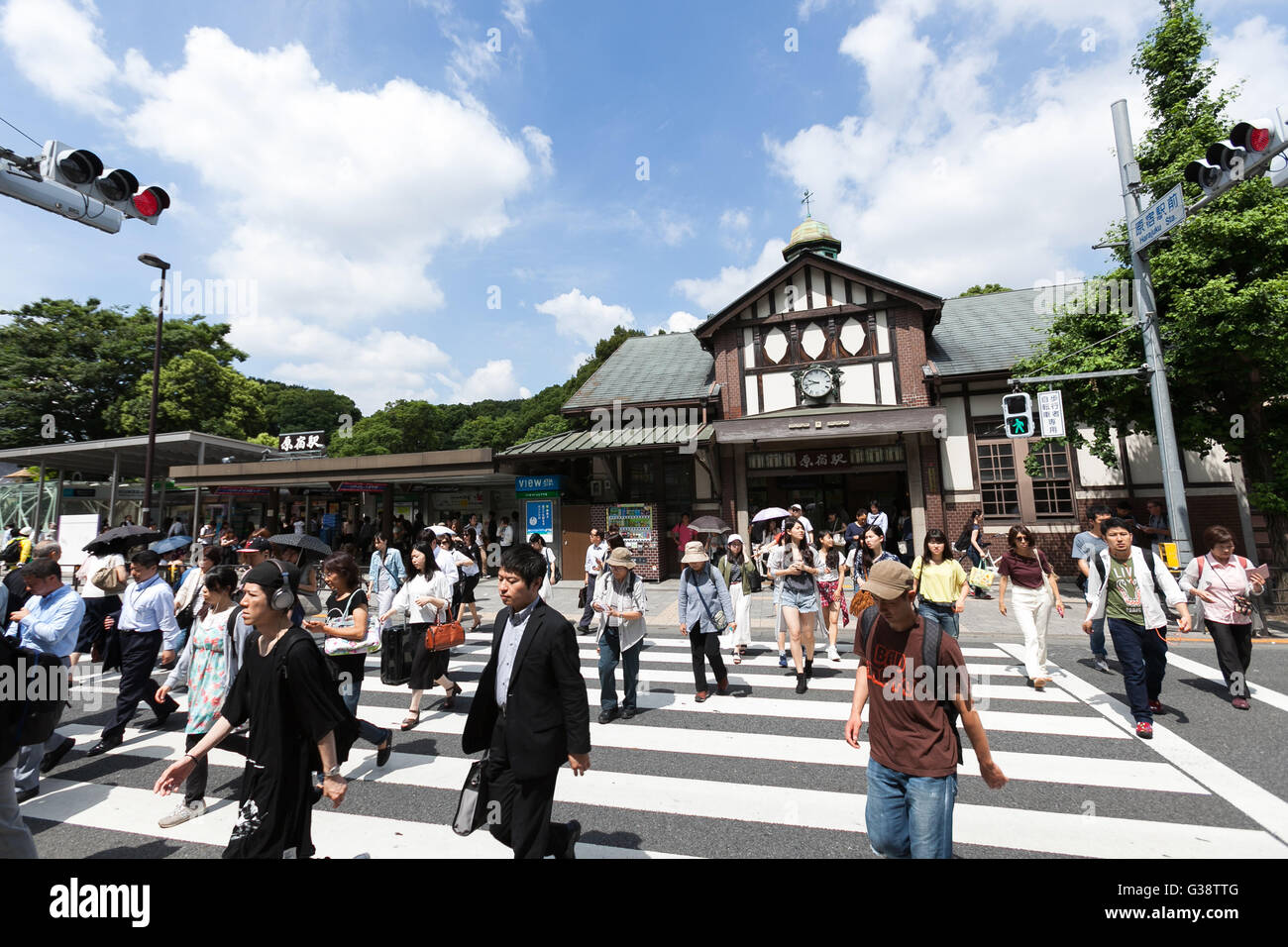 Tokyo, Giappone. Decimo Giugno, 2016. La gente a piedi passato Harajuku Station su Giugno 10, 2016, Tokyo, Giappone. Oriente Giappone Railway Co. ha annunciato il 8 giugno i piani per ricostruire la quasi secolo-vecchia stazione Harajuku con il progetto impostato per essere completato in tempo utile per le Olimpiadi 2020. L'attuale struttura in legno è creduto per essere il legno più vecchio edificio della stazione di Tokyo ed è stato costruito nel 1924 con uno stile architettonico europeo e la nuova stazione sarà più grande con un extra di piattaforma e una nuova porta sul lato ovest. Non è stato ancora deciso se la vecchia struttura sarà anche conservati come parte della p Foto Stock