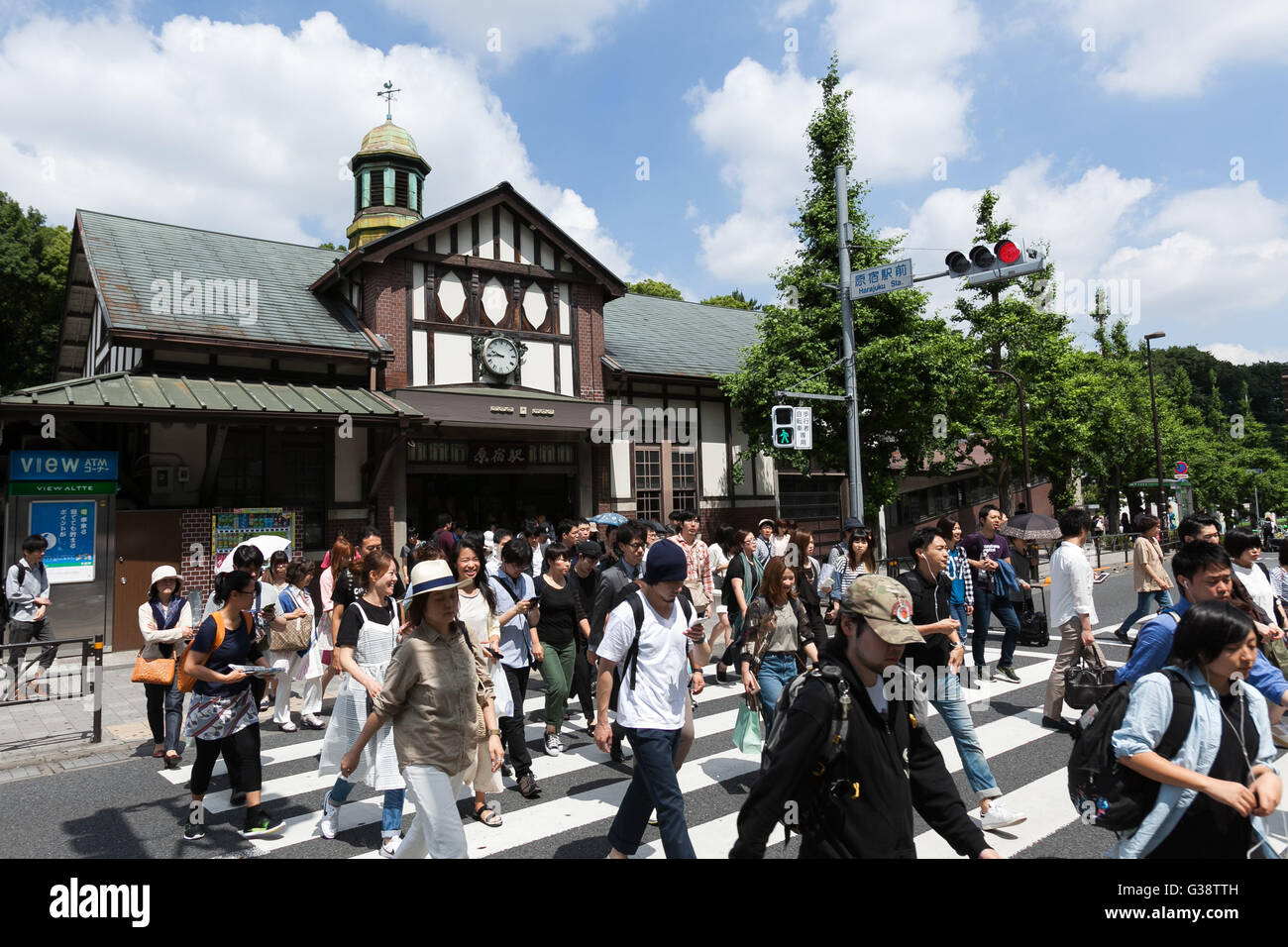 Tokyo, Giappone. Decimo Giugno, 2016. La gente a piedi passato Harajuku Station su Giugno 10, 2016, Tokyo, Giappone. Oriente Giappone Railway Co. ha annunciato il 8 giugno i piani per ricostruire la quasi secolo-vecchia stazione Harajuku con il progetto impostato per essere completato in tempo utile per le Olimpiadi 2020. L'attuale struttura in legno è creduto per essere il legno più vecchio edificio della stazione di Tokyo ed è stato costruito nel 1924 con uno stile architettonico europeo e la nuova stazione sarà più grande con un extra di piattaforma e una nuova porta sul lato ovest. Non è stato ancora deciso se la vecchia struttura sarà anche conservati come parte della p Foto Stock