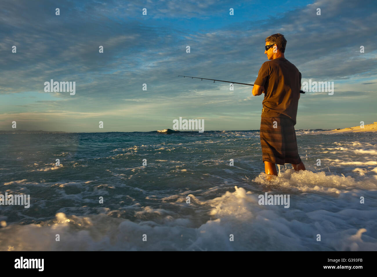 Brad Osborn pesca di Papio al sorgere del sole sulla spiaggia a Namotu Island, Isole Figi Foto Stock