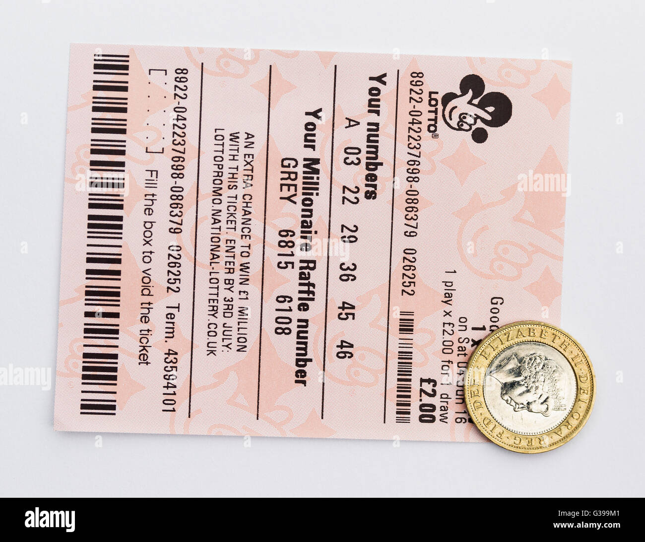 Un due pound UK Lotto ticket con un due pound coin. Foto Stock