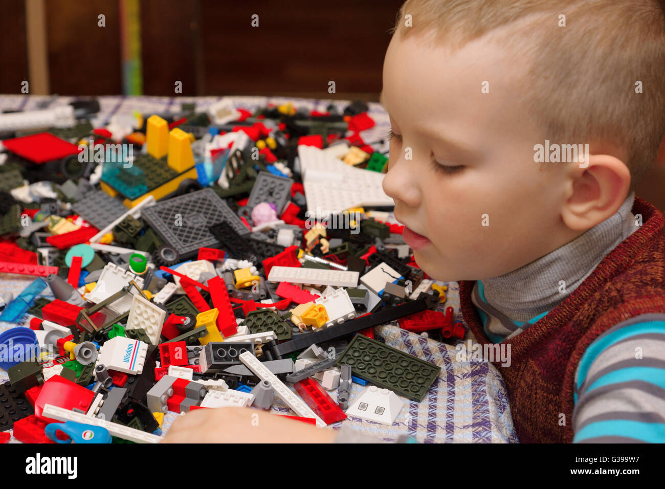 Ragazzo seduto al tavolo e cosa che crea una struttura complessa Foto Stock