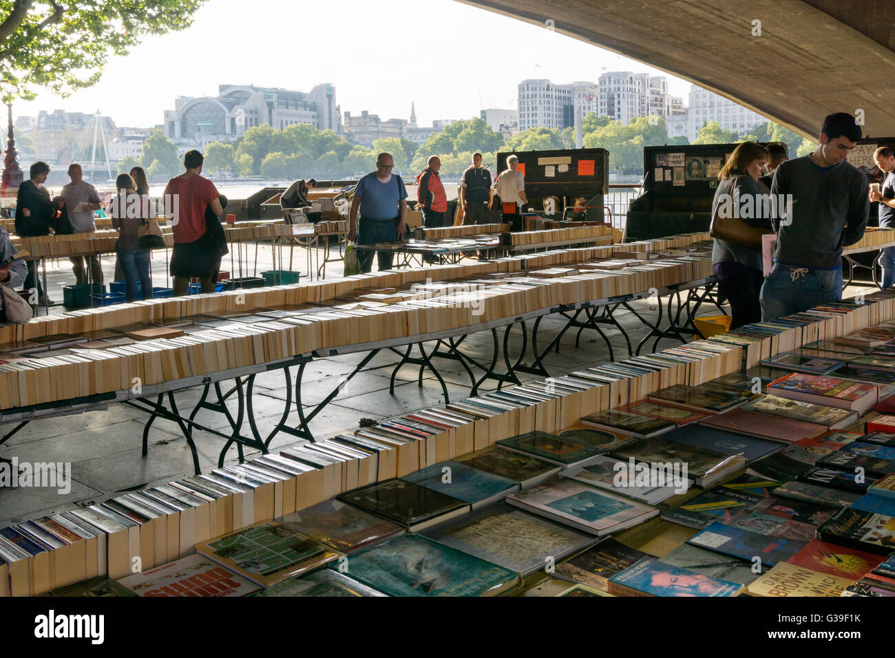 La gente del posto e i turisti di sfogliare i libri presso il Southbank Prenota mercato sotto il ponte di Waterloo, Londra. Foto Stock
