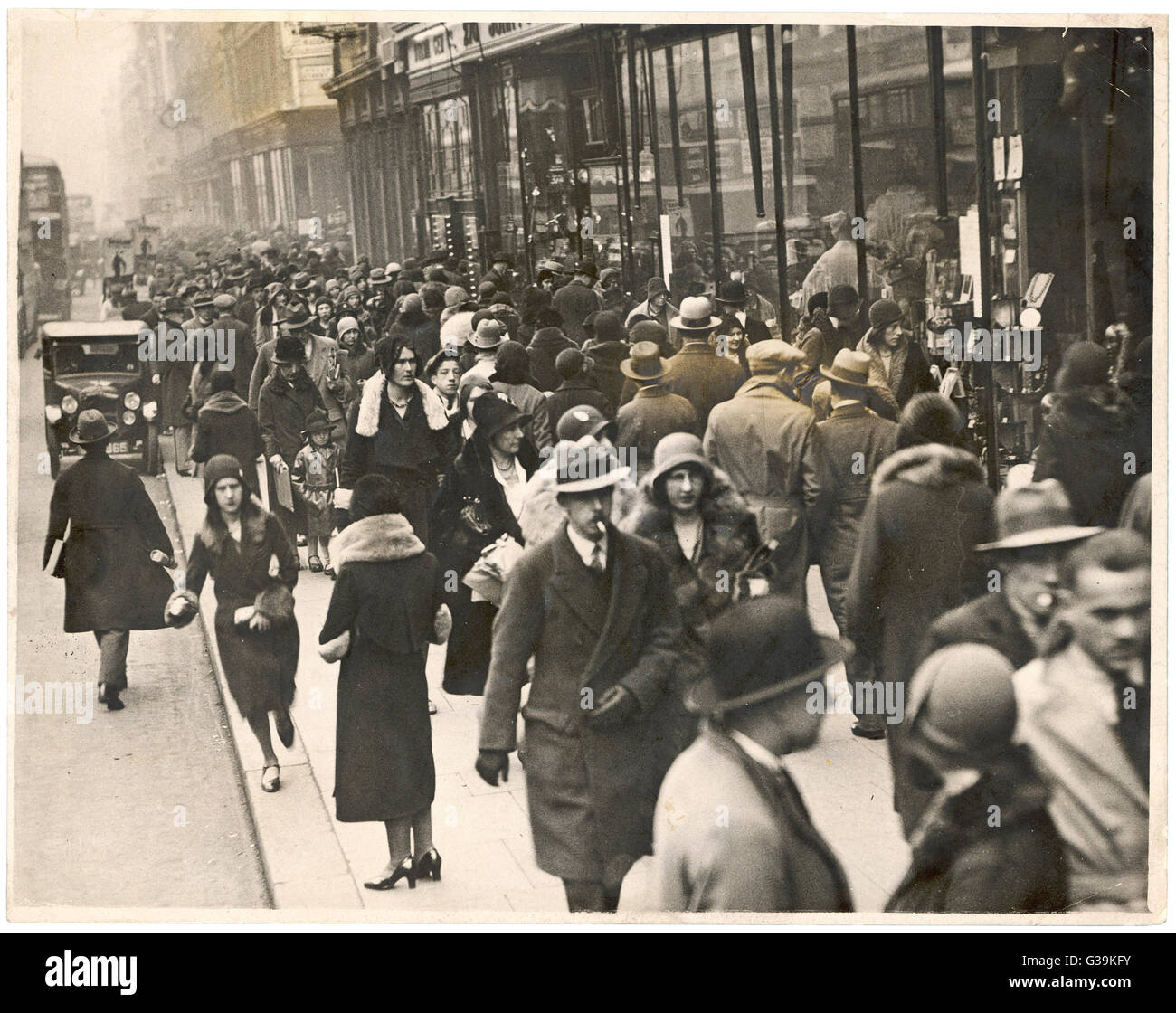 La Folla di smart shopper, prevalentemente di indossare cappelli, andare circa la loro attività in un central London street. Data: 1930 Foto Stock