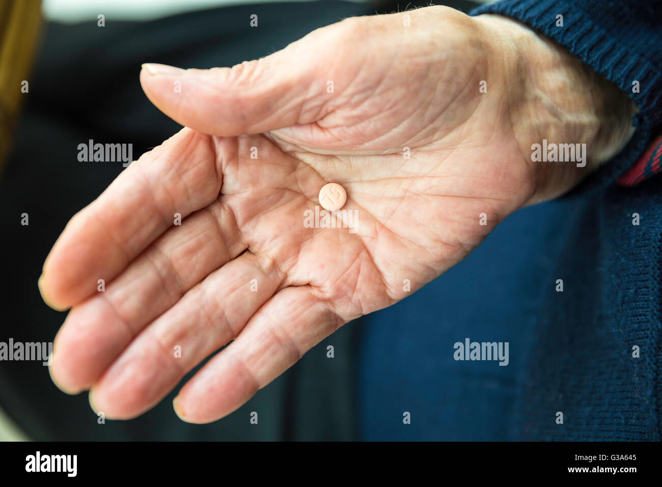 Anziana donna turca in possesso di una singola pastiglia nel suo palm Foto Stock
