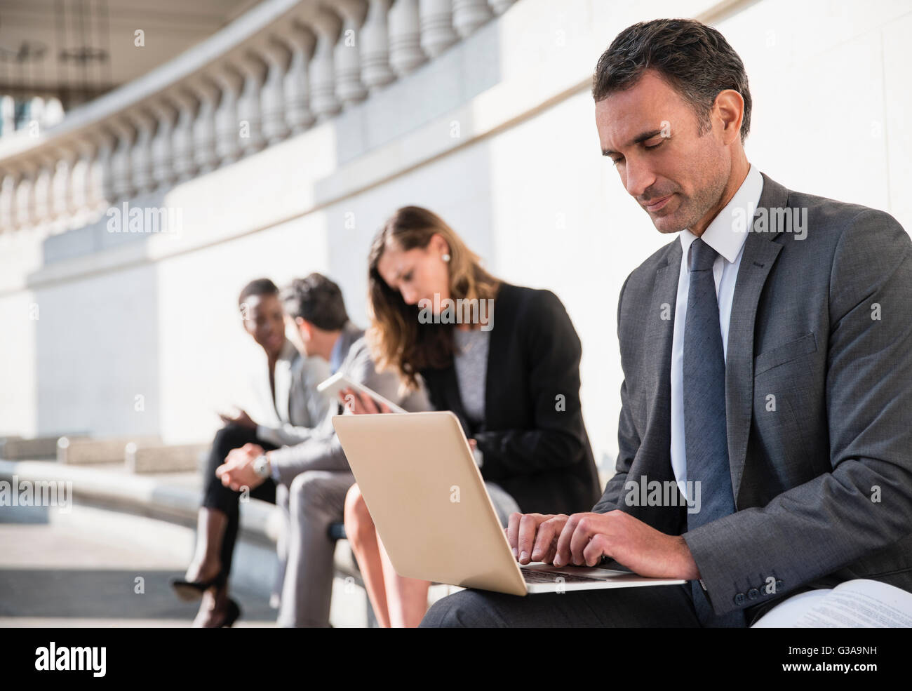 Imprenditore aziendale utilizzando laptop sul banco di prova all'aperto Foto Stock