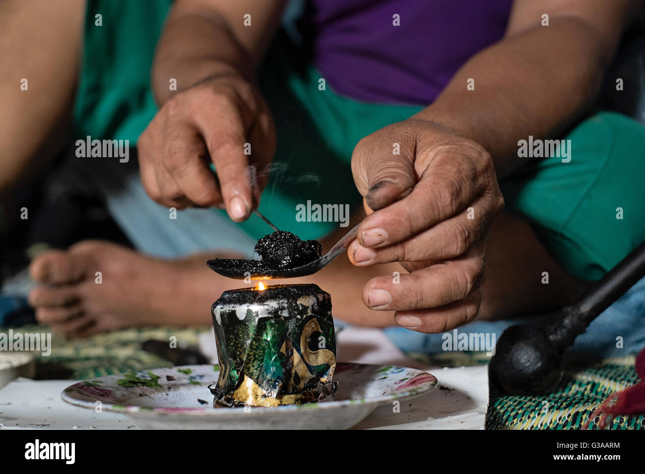 Un abitante di un villaggio si prepara una pallina di oppio per fumatori in Luang Prabang, Luang Prabang Provincia, Laos Foto Stock