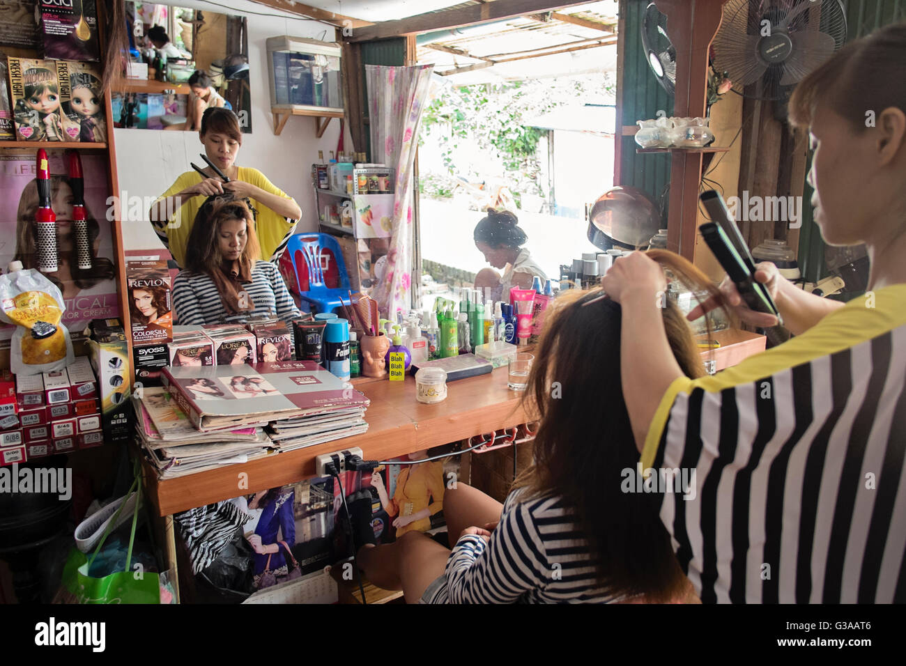 Una donna ha il suo taglio di capelli in un salone di bellezza in Sakkarine Road, divieto Watsene, Luang Prabang, Luang Prabang Provincia, Laos Foto Stock