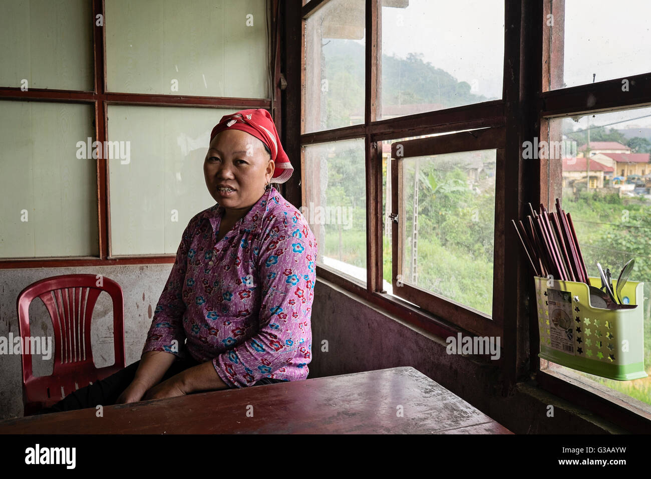 Un Rosso Dao donna si siede in un bar nel villaggio di Ban Khoang, Sapa, Lao Cai Provincia, Vietnam Foto Stock