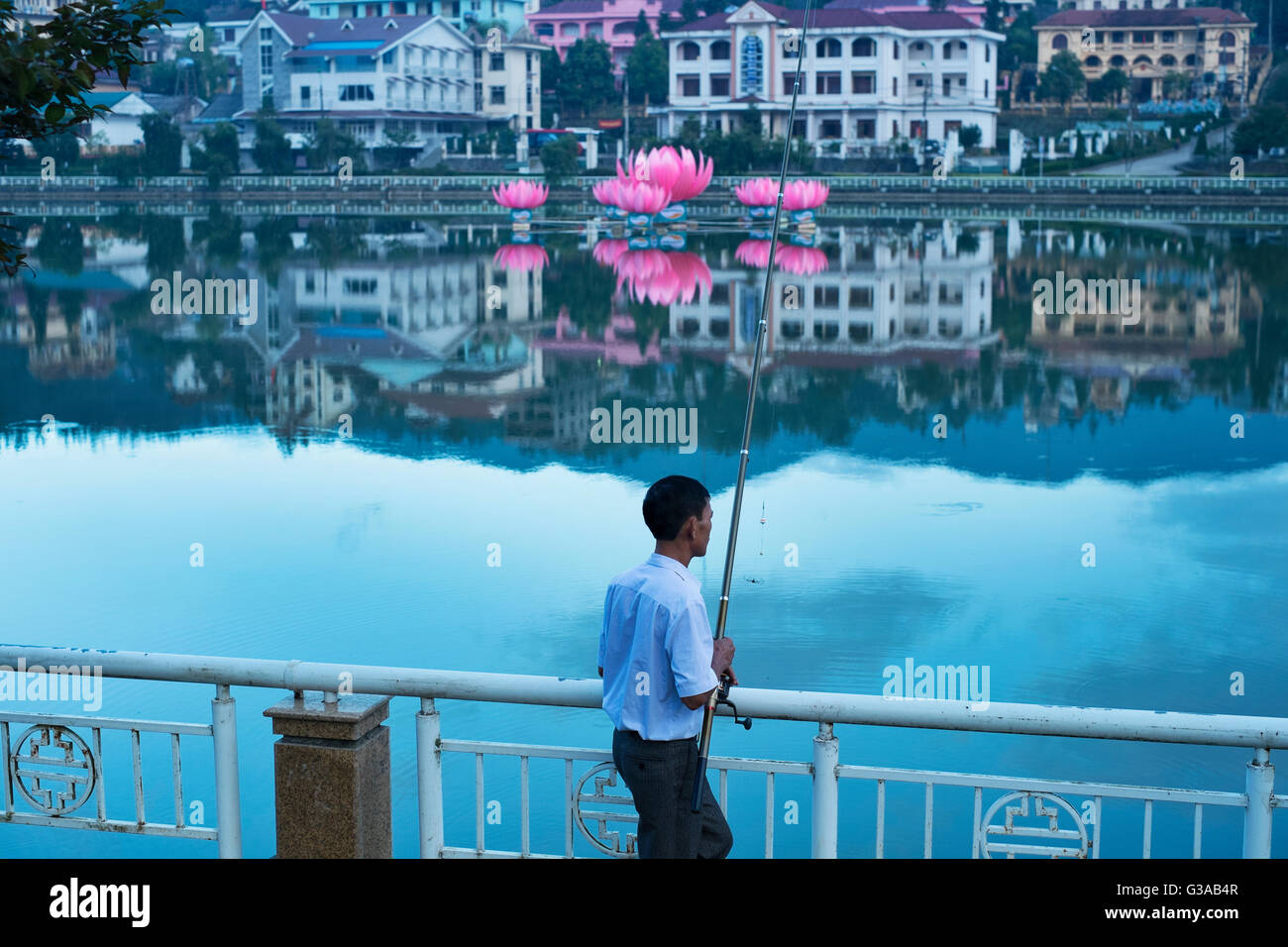 Un uomo di pesci nel Lago di Sapa nel centro di Sapa, Lao Cai provincia, Vietnam Foto Stock