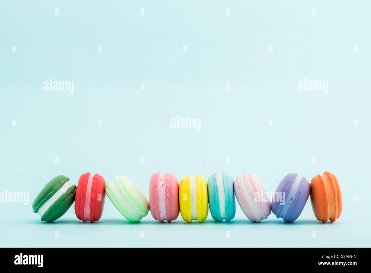 Francese macaron colorati su sfondo color pastello, spazio di copia Foto Stock