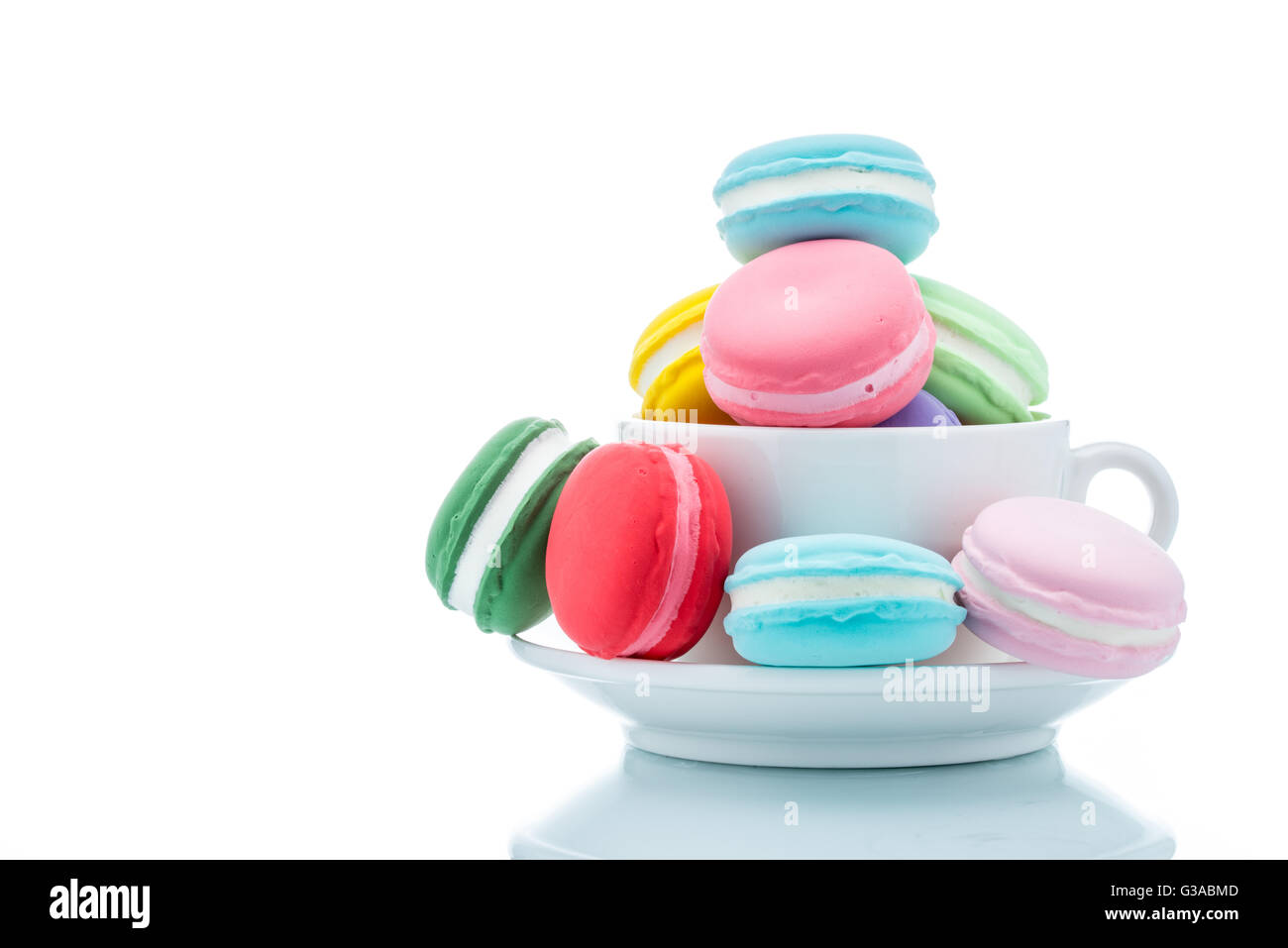 Francese macaron colorati pile in tazza di caffè su sfondo bianco Foto Stock