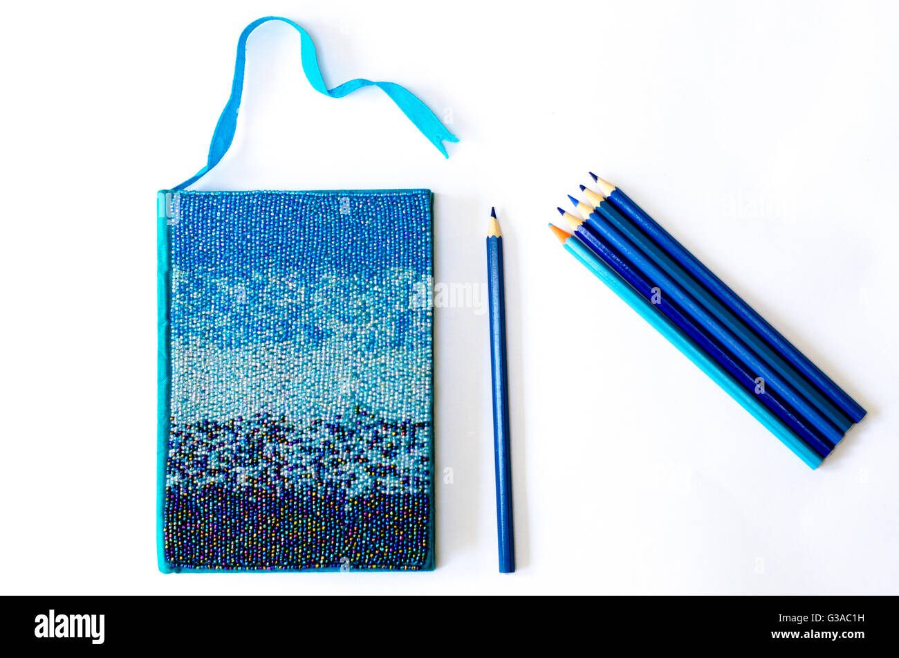 Matite di colore blu e blu notebook, sul bianco pulito scrivania Foto Stock