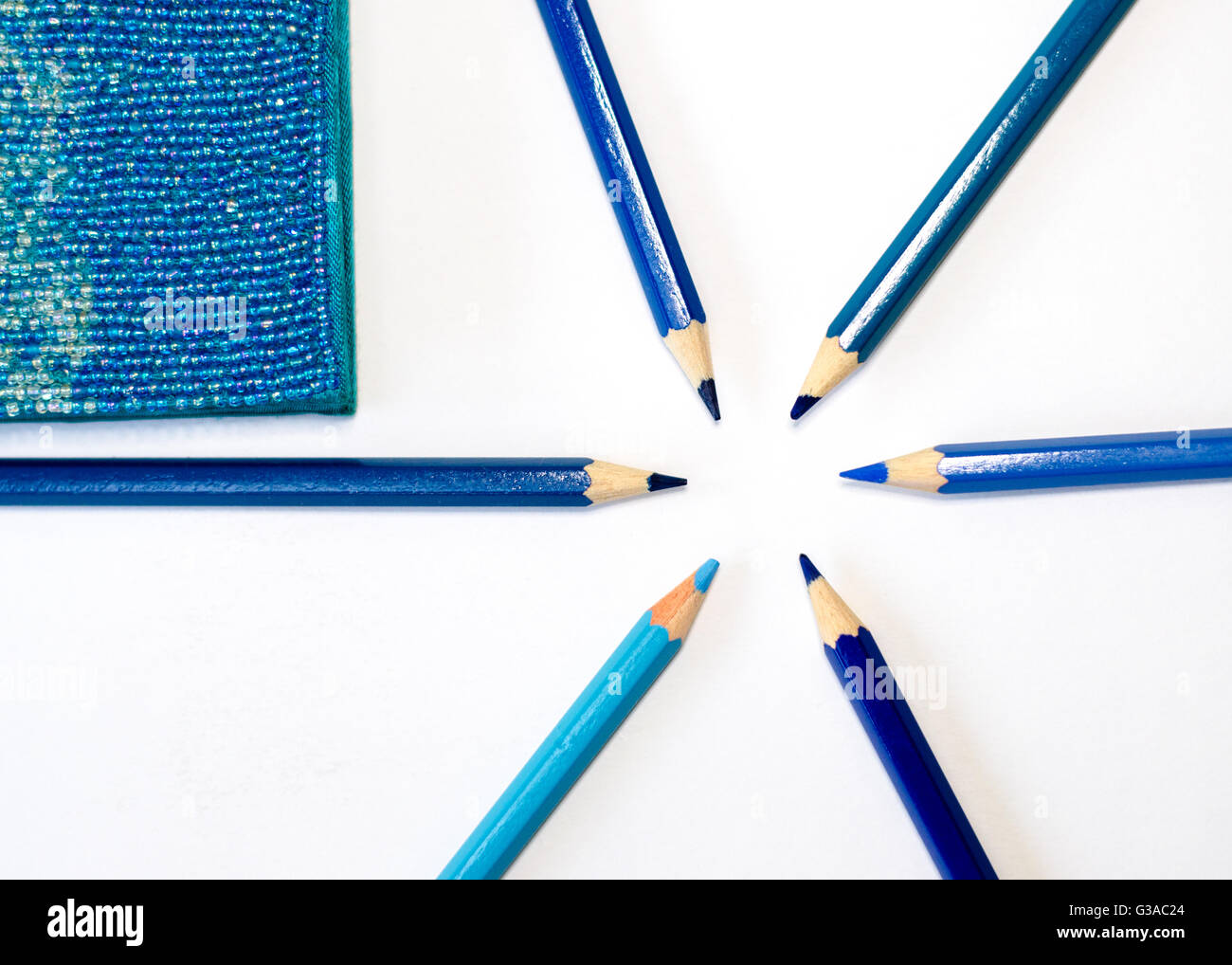 Matite di colore blu e blu notebook, sul bianco pulito scrivania Foto Stock