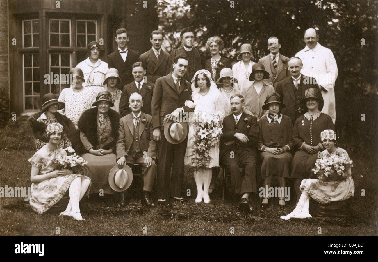 Grande festa di matrimonio fotografia - circa 1920s. Il Vicario, genitori, bridesmaids i parenti e gli amici tutti sono in primo piano. Data: circa 1920s Foto Stock