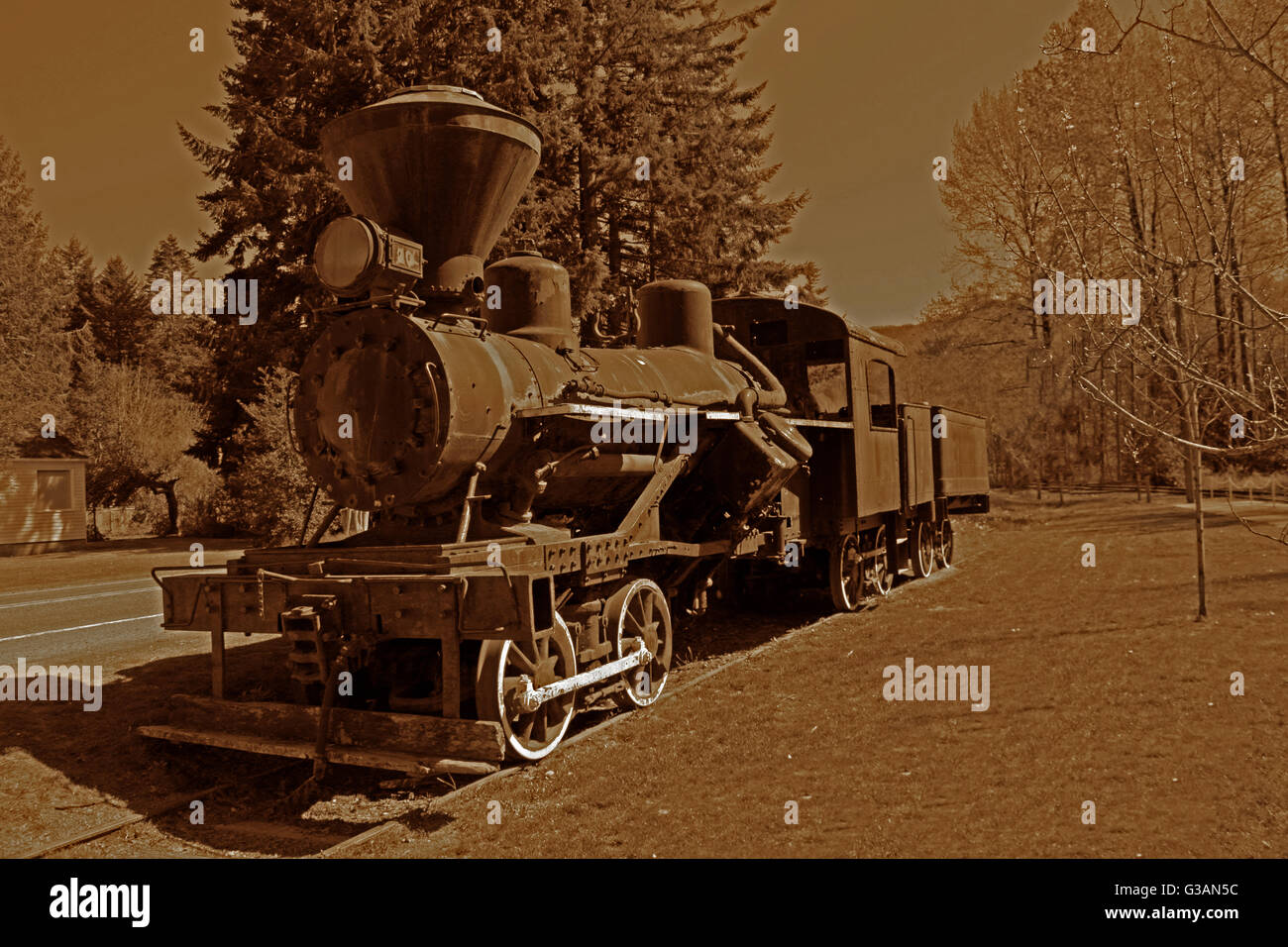 Antica locomotiva, seduta sul ciglio della strada, ricordando di moderne "road kings' del viaggio e l'industria da giorni passati. Foto Stock