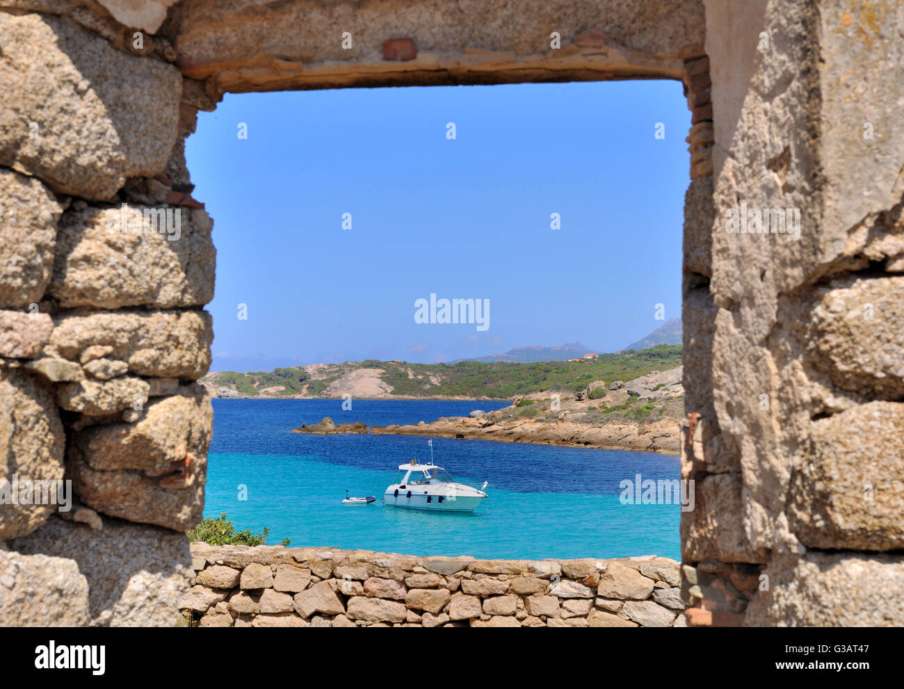 Si affaccia sul mare blu turchese attraverso una finestra di un vecchio edificio in pietra Foto Stock