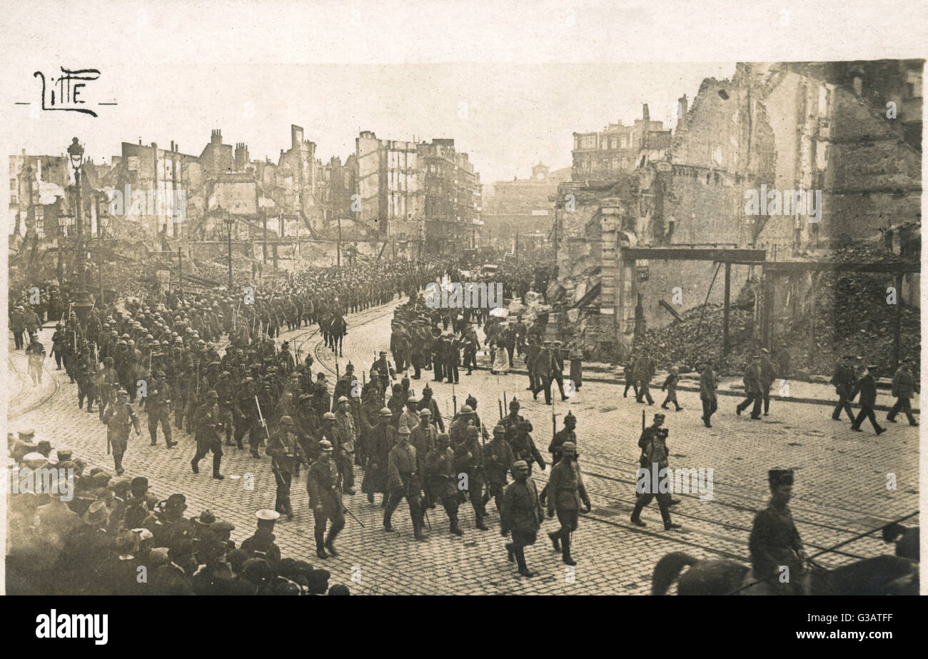Esercito Tedesco arrivando a Lille in Francia il 12 ottobre 1914. Gli edifici presentano danni causati dai bombardamenti. La stazione ferroviaria può essere visto in lontananza. Data: 1914 Foto Stock