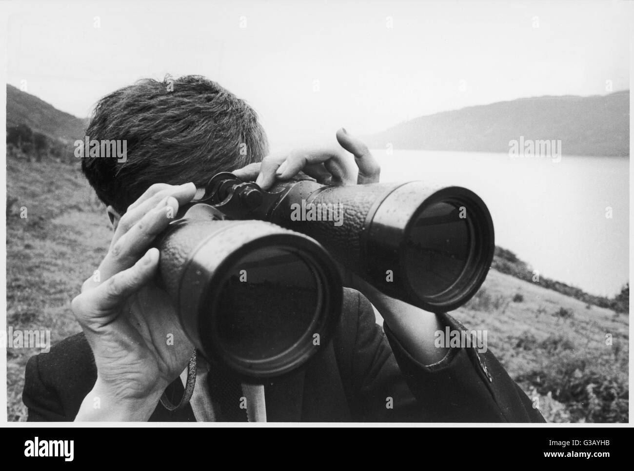 Guardando per il mostro di Loch Ness attraverso un paio di binocoli. Foto Stock