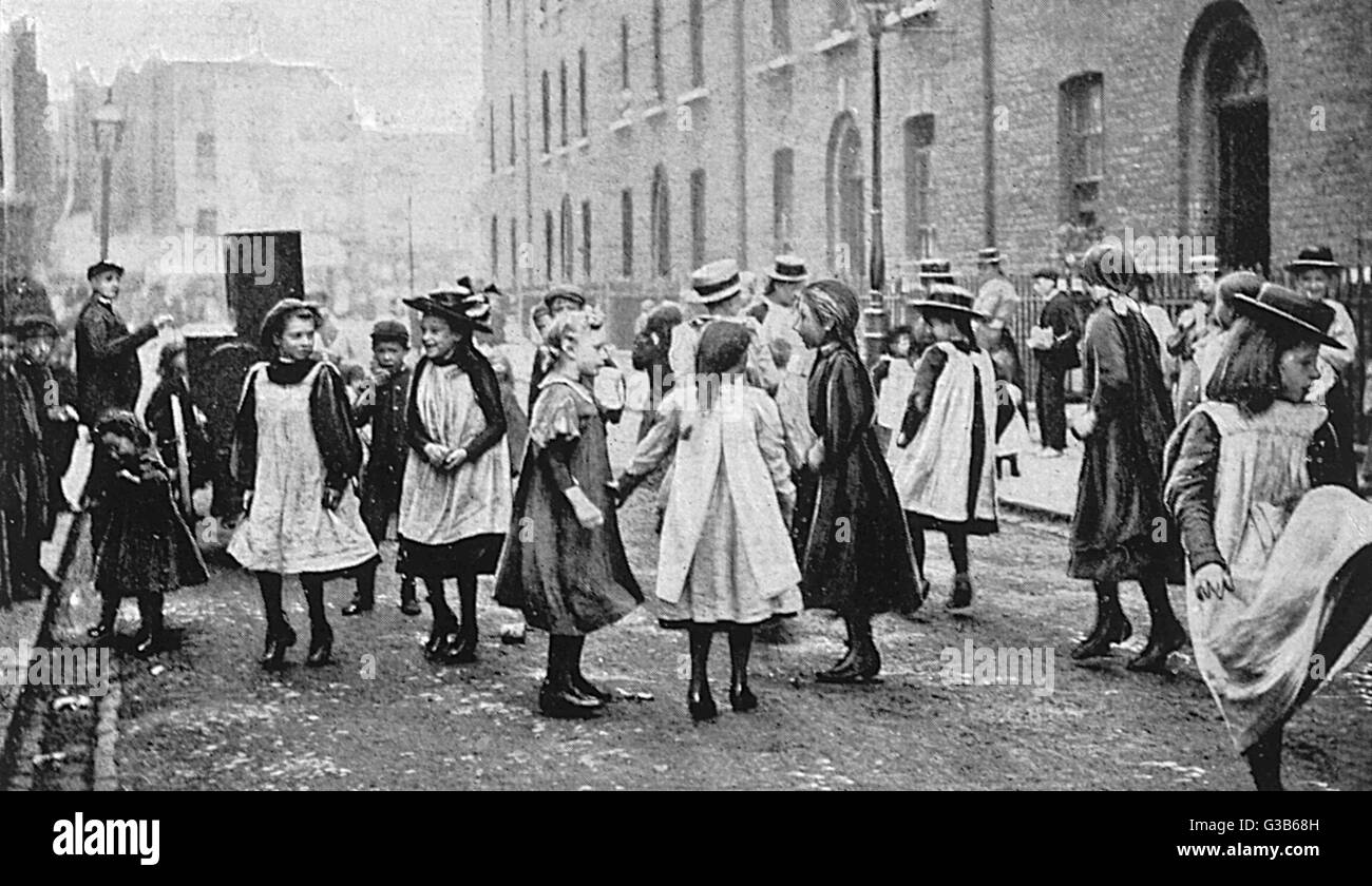 Ragazze in una strada di Londra a ballare con la musica di un organetto Data: circa 1900 Foto Stock