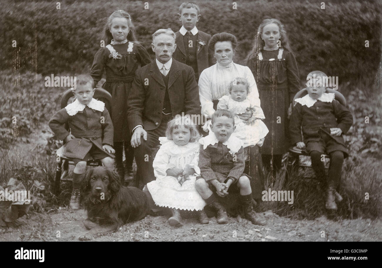 Un Edwardian gruppo familiare di dieci con il loro cane in un giardino. Data: circa 1900s Foto Stock