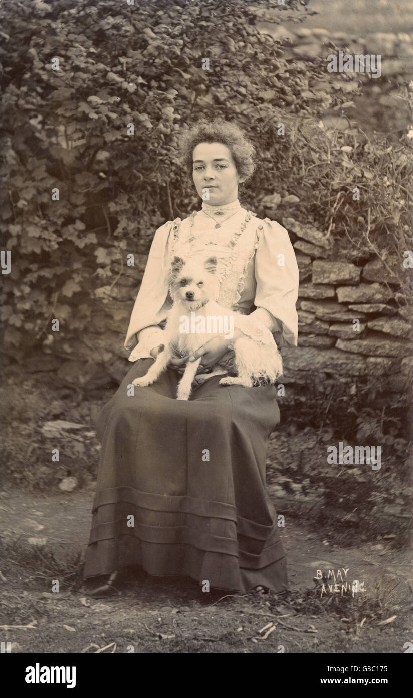 Giovane donna con un terrier in giardino Foto Stock