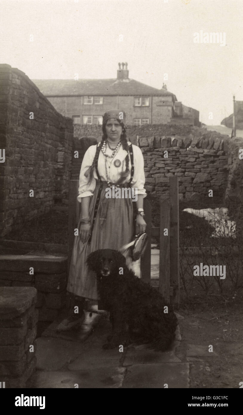 Donna in costume zingaro con un cane in giardino Foto Stock