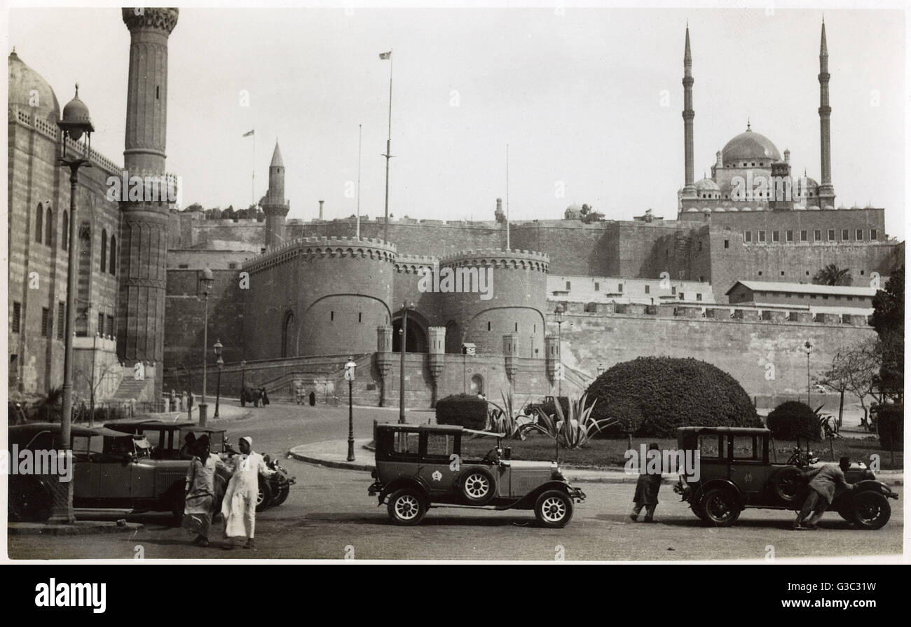 Alcuni graziosi 1920s auto parcheggiata vicino al il Saladino Cittadella del Cairo sulla collina di Moqattam vicino al centro del Cairo, Egitto. Il El Azab Gate può essere visto (centro) nonché il Muhammed Ali moschea (posteriore sinistra). Muhammad Ali Pasha (1769 - 1849), è considerato un Foto Stock
