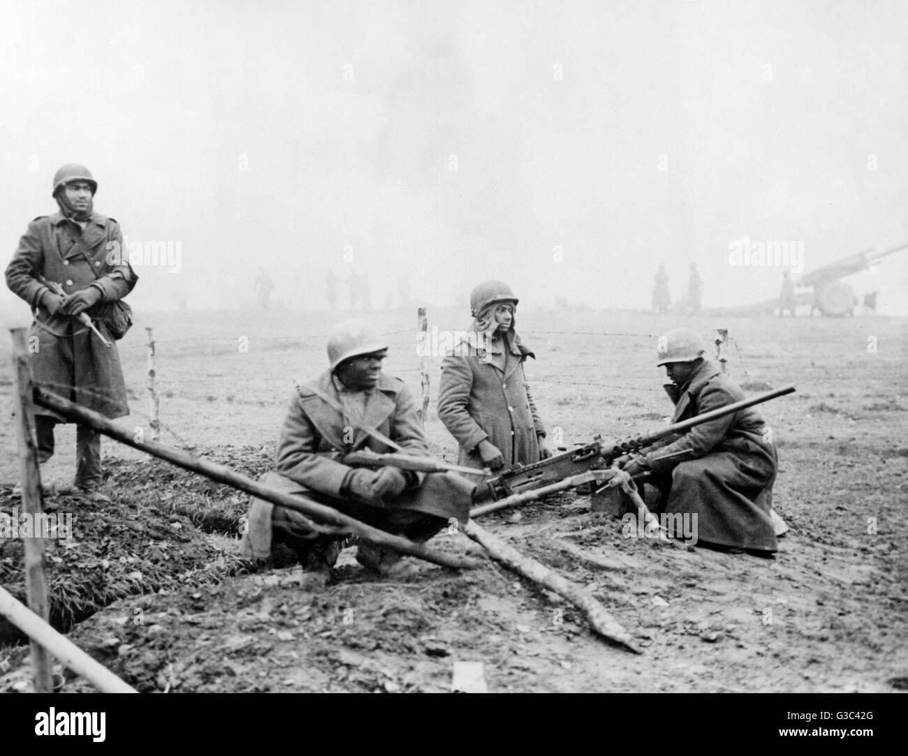 Un Americano campo unità di artiglieria scavare nel lungo una strada belga, in posizione di attesa a terra contro il tedesco della controffensiva nella zona delle Ardenne del Belgio che divenne noto come la Battaglia di Bulge. Da sinistra a destra, privato G.F.Morris di New York Foto Stock