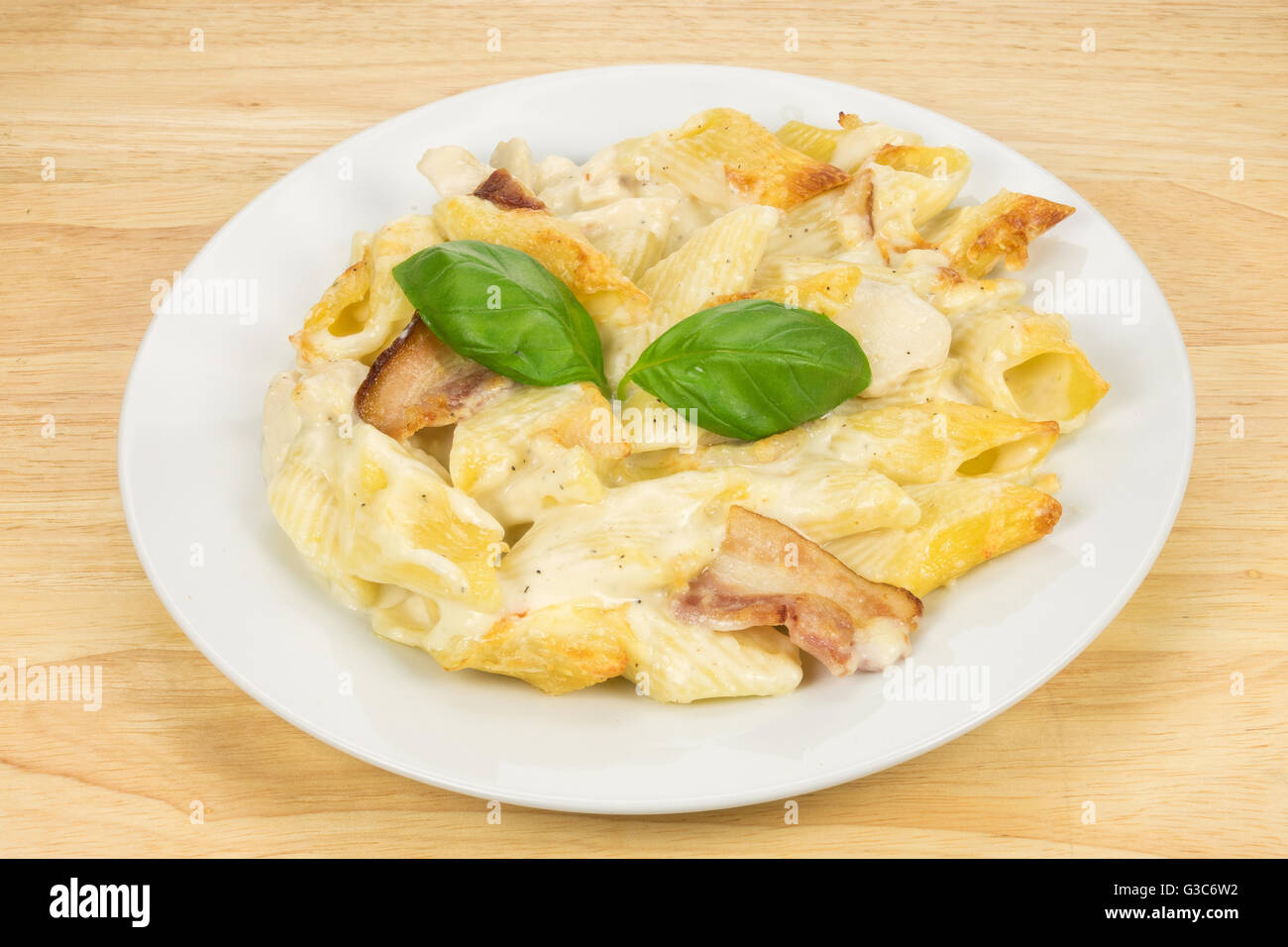 Il pollo e la pancetta cuocere la pasta pasto servito su una piastra bianca Foto Stock