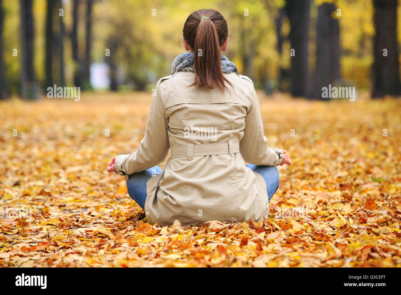Donna meditator in autunno park Foto Stock