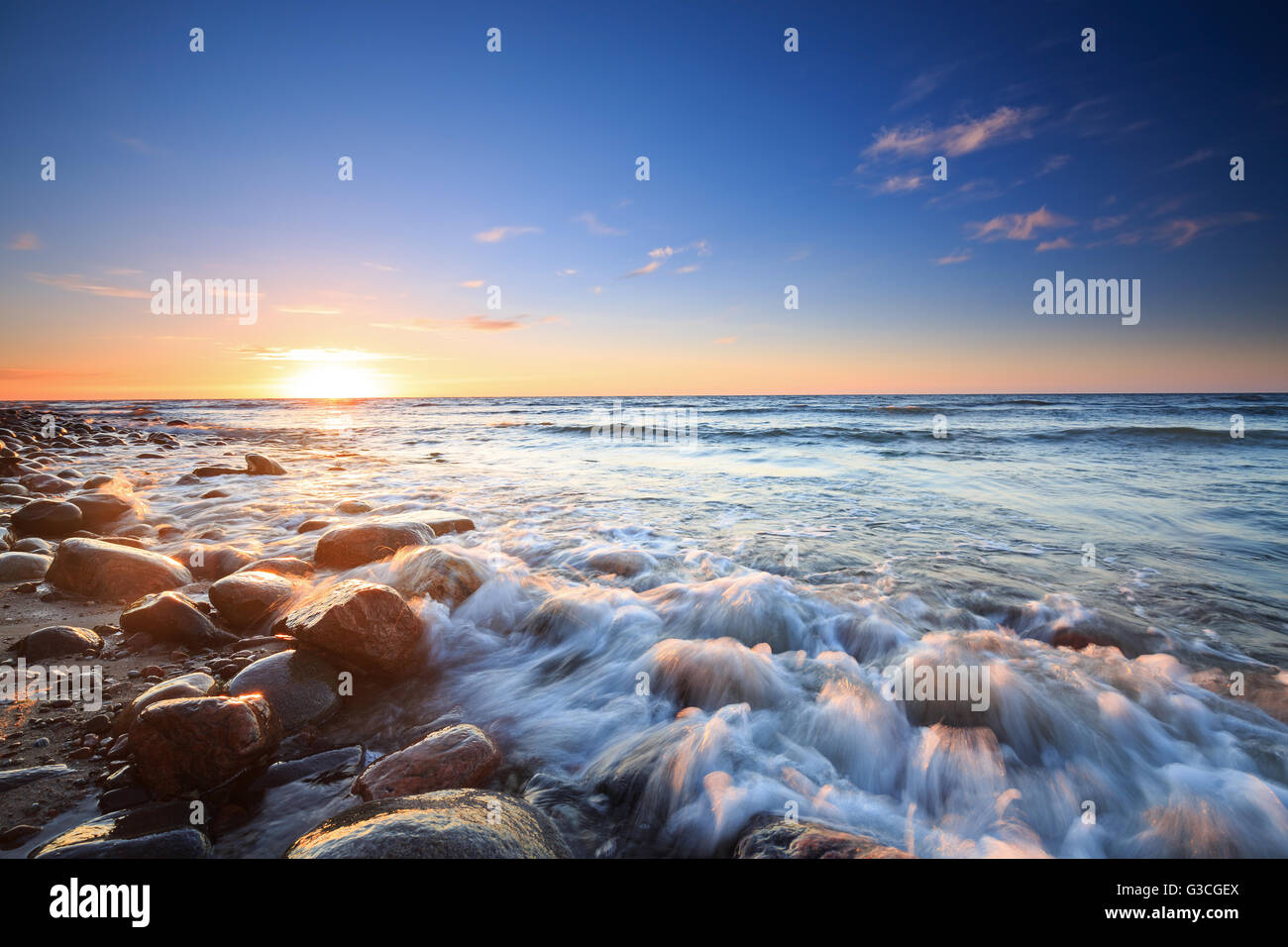 Tramonto sul Mar Baltico. La spiaggia di ciottoli in Rozewie Foto Stock