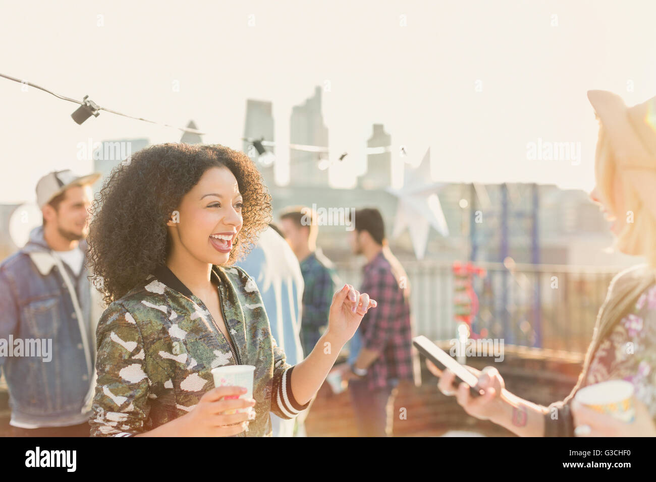 Entusiasti delle giovani donne godendo di partito sul tetto Foto Stock