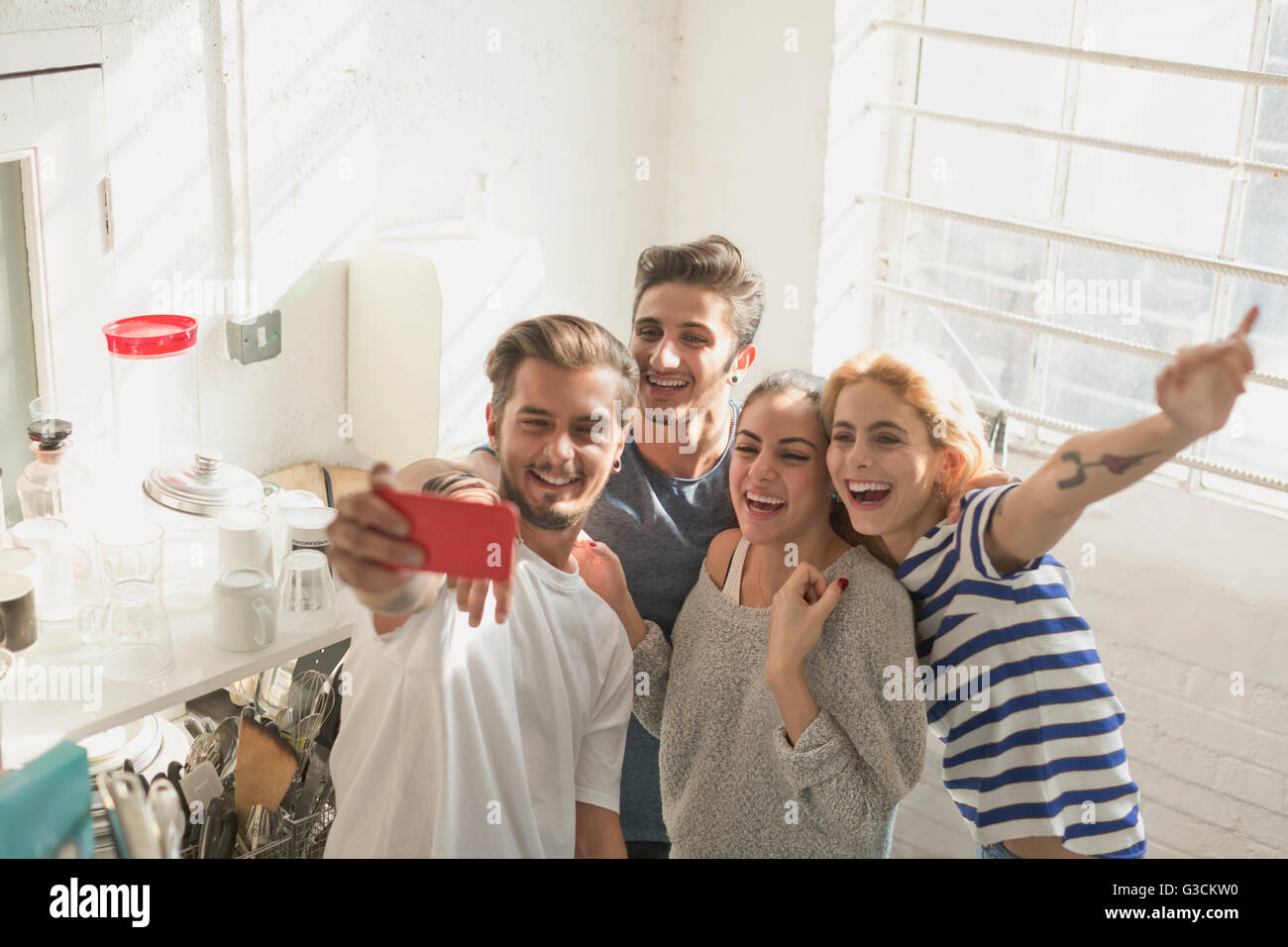 Entusiasta giovane adulto coinquilini tenendo selfie in cucina Foto Stock