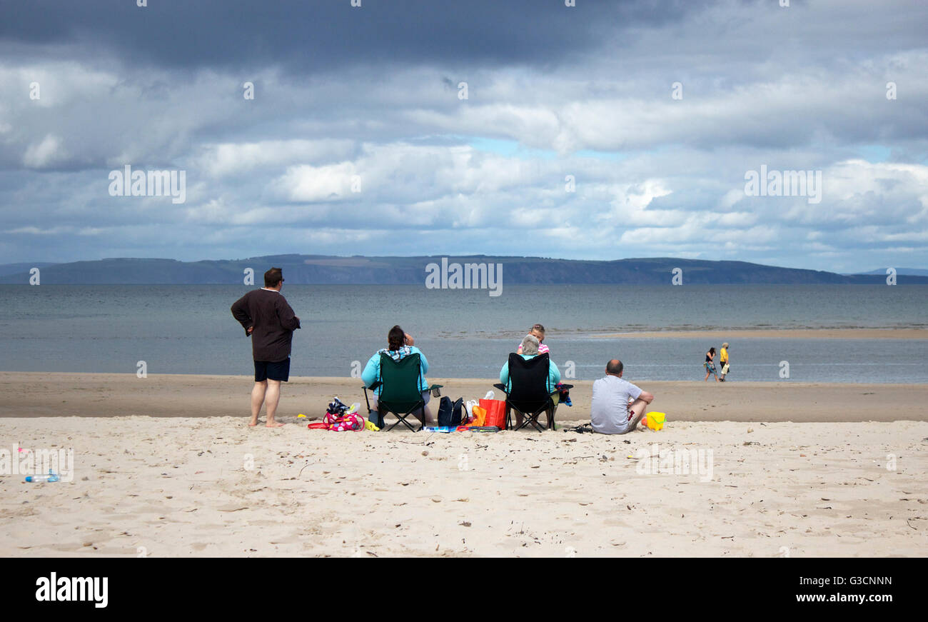 Scozia, Highlands, Nairn, stampe nel sabbia, Scottish Scottish Scotland, Nairn Beach, Blue Skies, Family sitting on the Beach, Beach outing, Cloudy Foto Stock