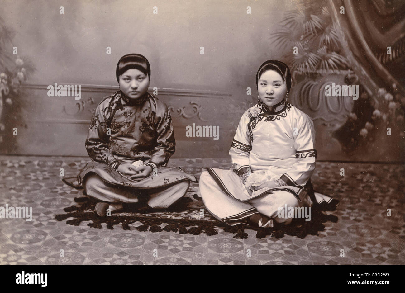 Due ragazze cinesi seduti su un tappeto piccolo Foto Stock