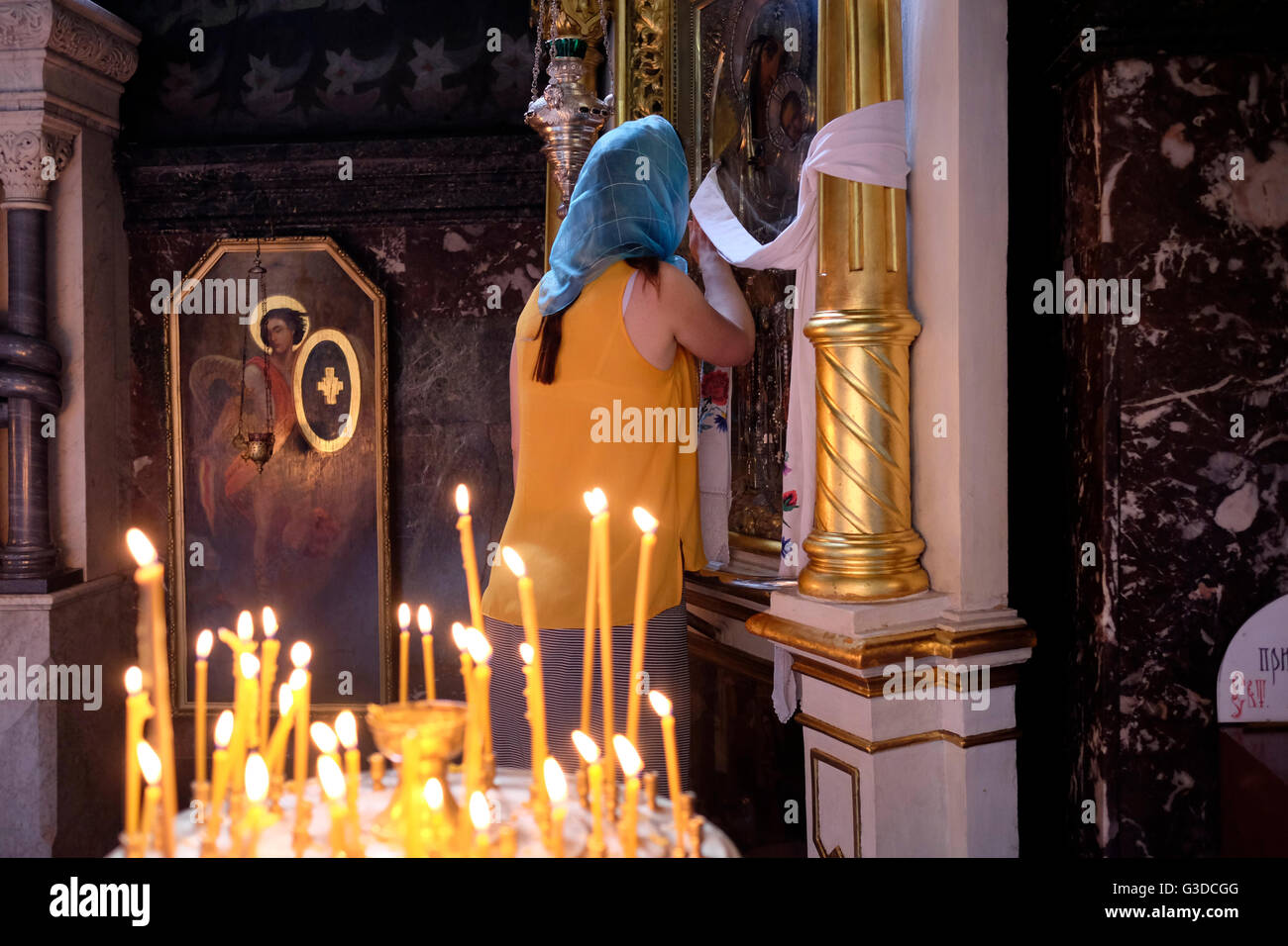 Un Ortodosso Ucraino devoto pregando davanti ad una icona dopo un servizio di preghiera da ucraino Chiesa Ortodossa del Patriarcato di Kiev a san Volodymir cattedrale nel centro di Kiev, Ucraina Foto Stock